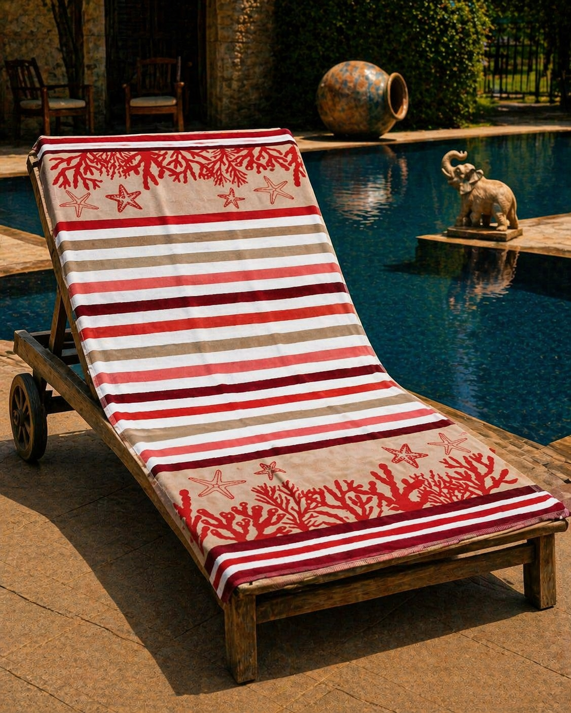 Red and beige striped beach towel with red coral and starfish motifs at top and bottom borders