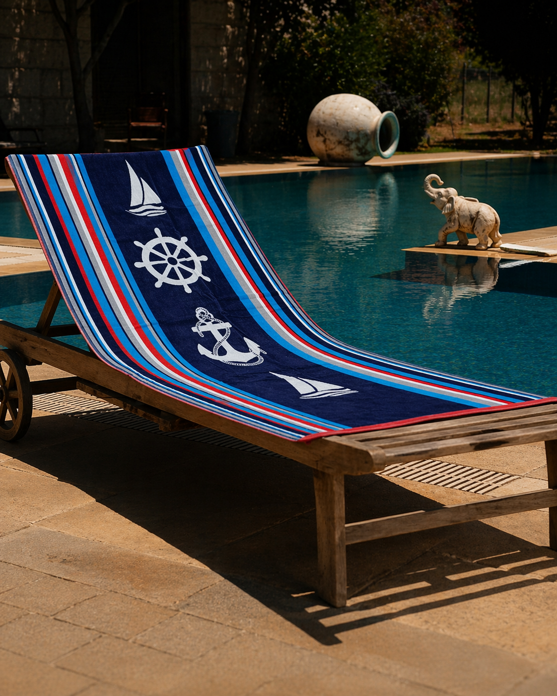 Navy blue beach towel with white anchor, sailboat and ship wheel motifs on red, white and blue stripes