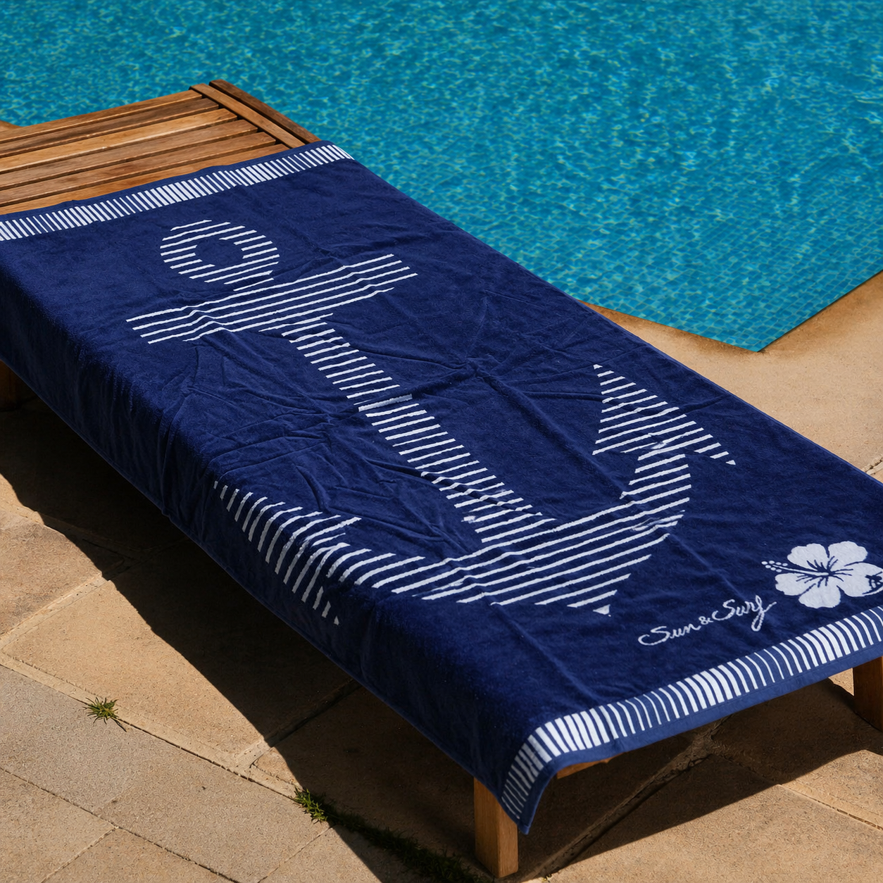Navy blue beach towel with large striped white anchor, hibiscus flower and Sun & Surf text