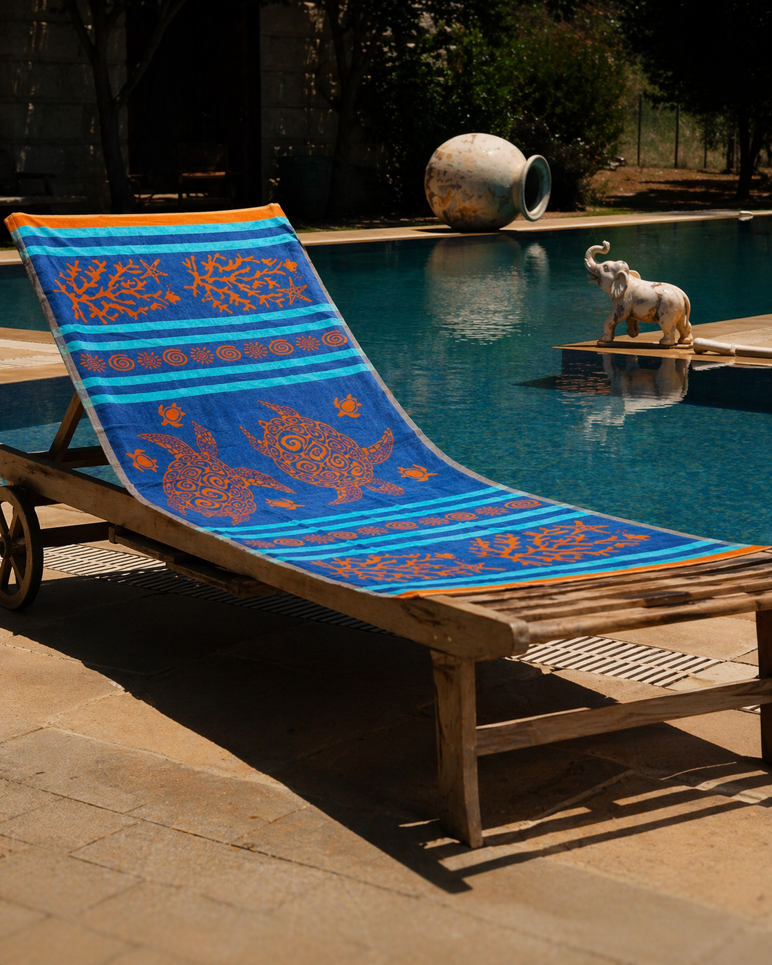 Blue beach towel with orange sea turtles, coral, starfish and sun motifs on turquoise striped background