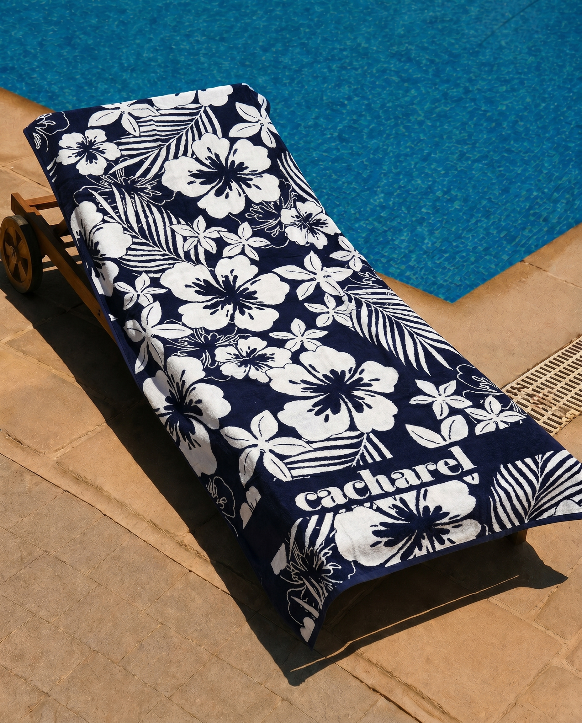 Midnight Hibiscus Beach Towel draped over a lounge chair