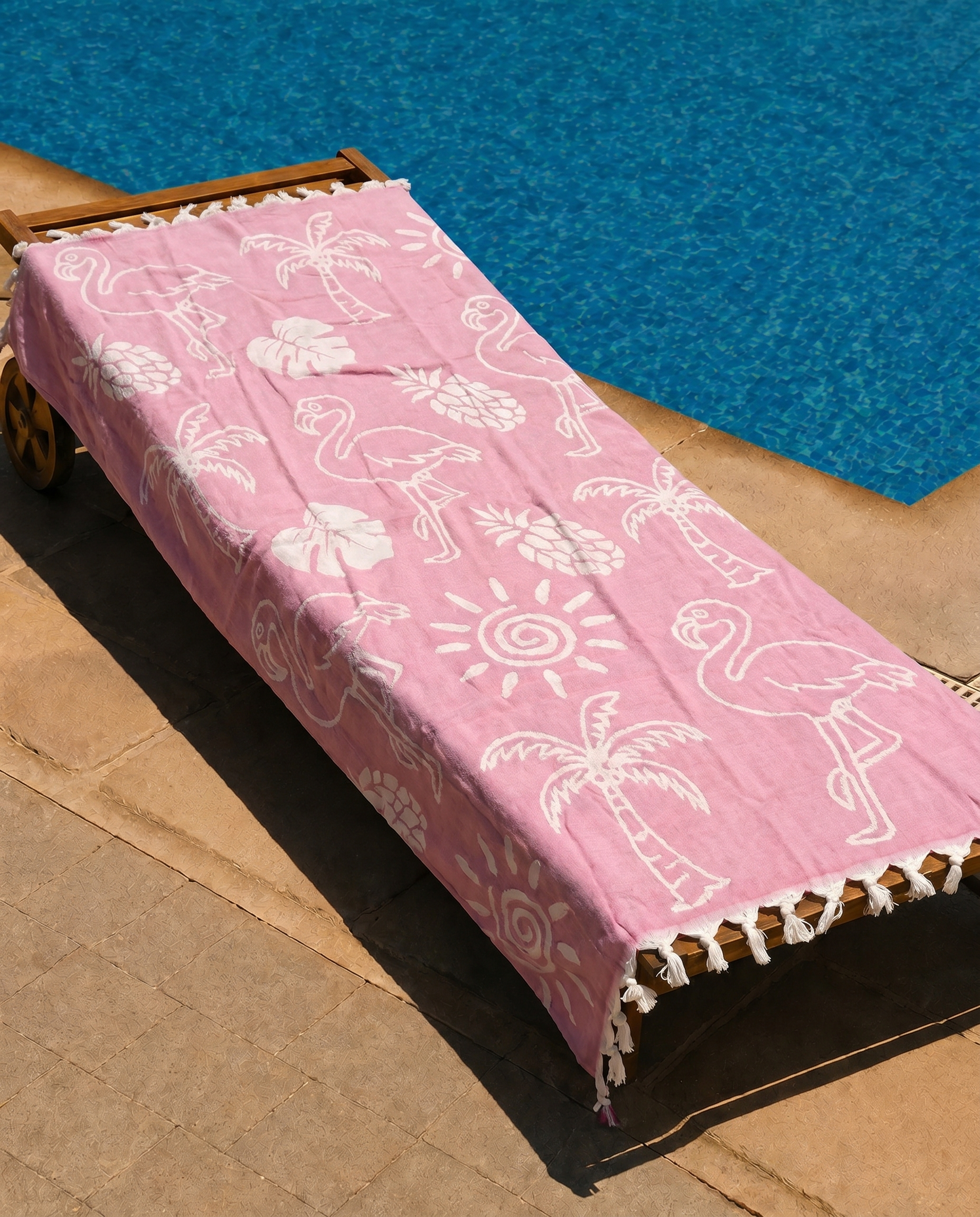 Pink Flamingo Beach Towel draped over a lounge chair