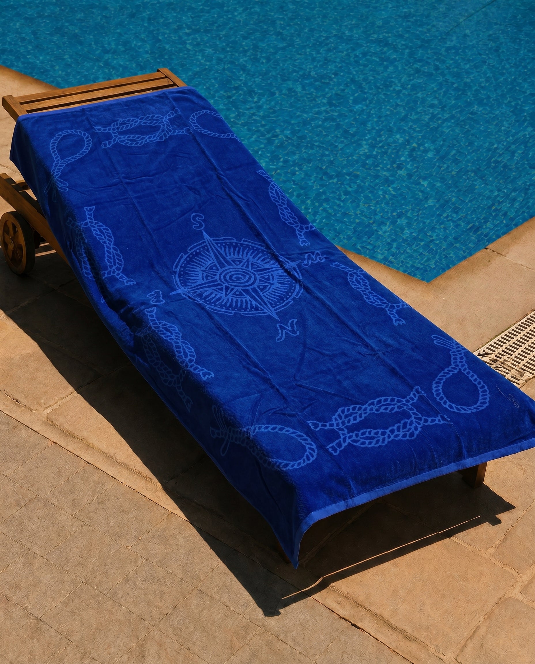 Royal Compass Beach Towel draped over a lounge chair