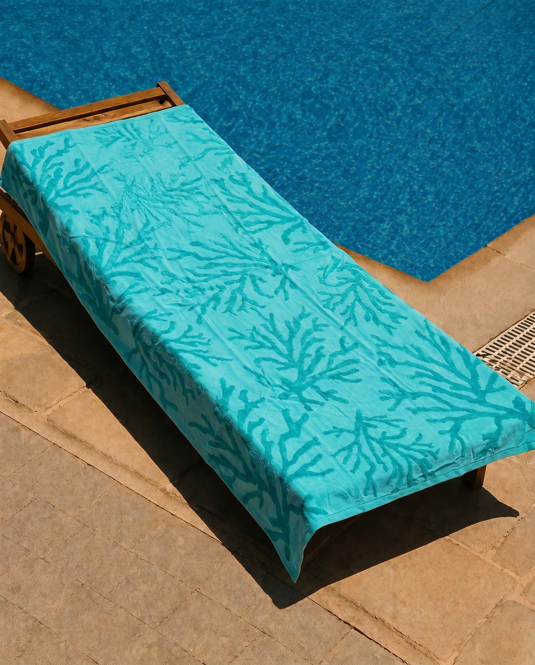 Turquoise Reef Beach Towel draped over a lounge chair