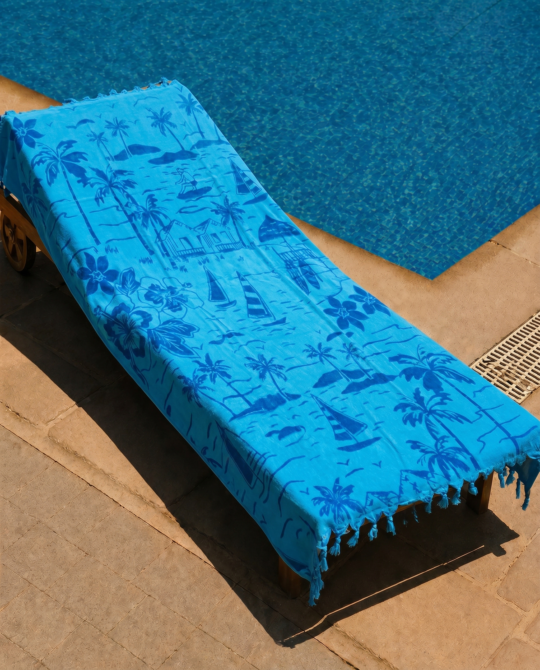Azure Paradise Beach Towel draped on a lounge chair
