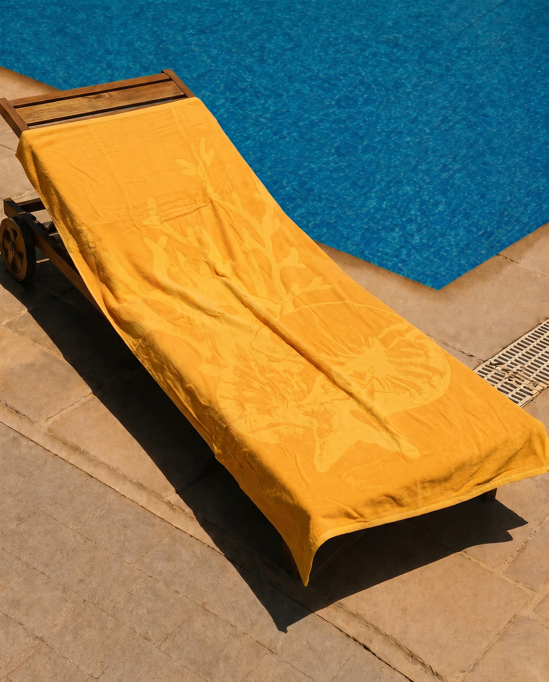 Saffron Shell Beach Towel draped on a lounge chair