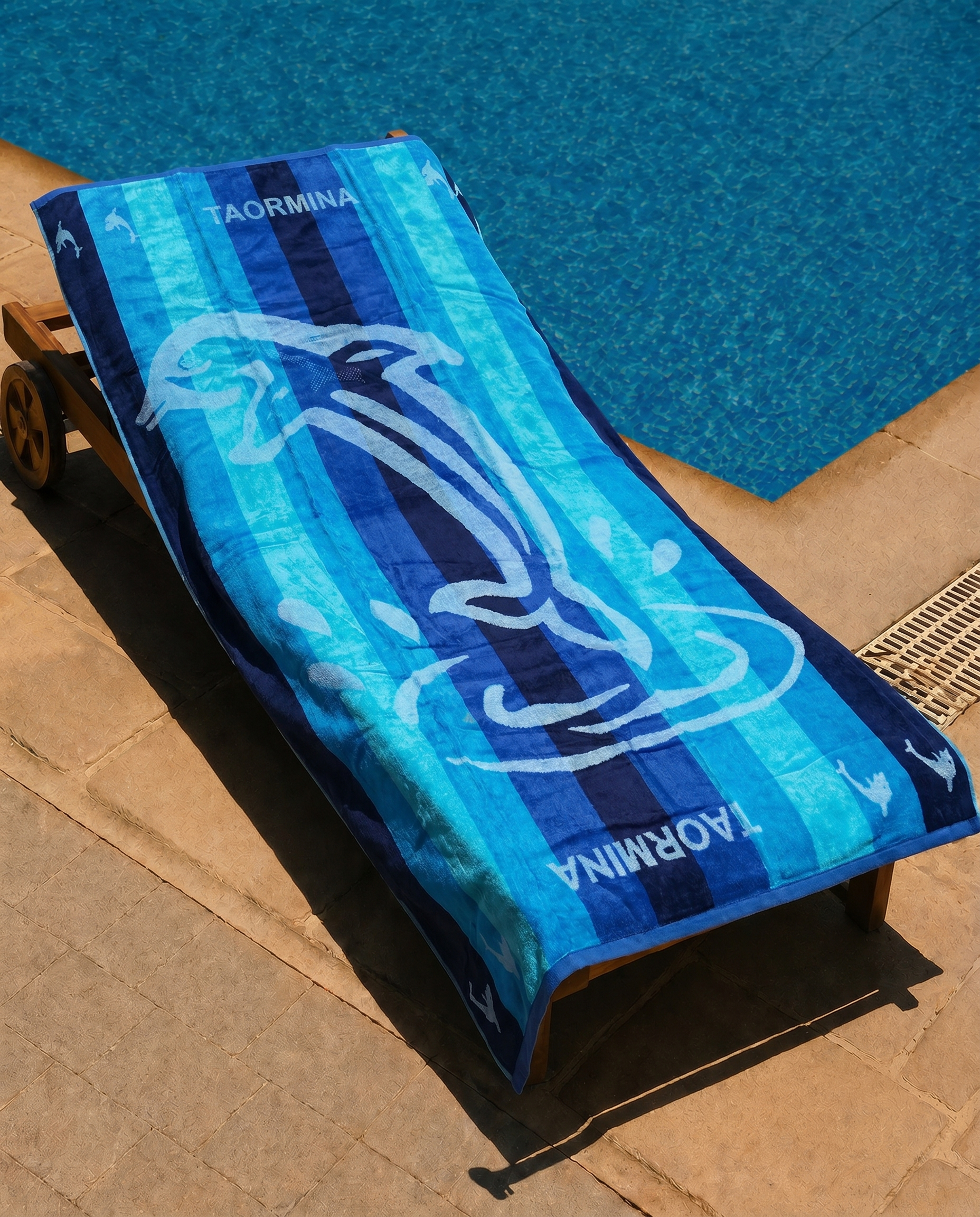 Dolphin Bay Beach Towel draped on a lounge chair