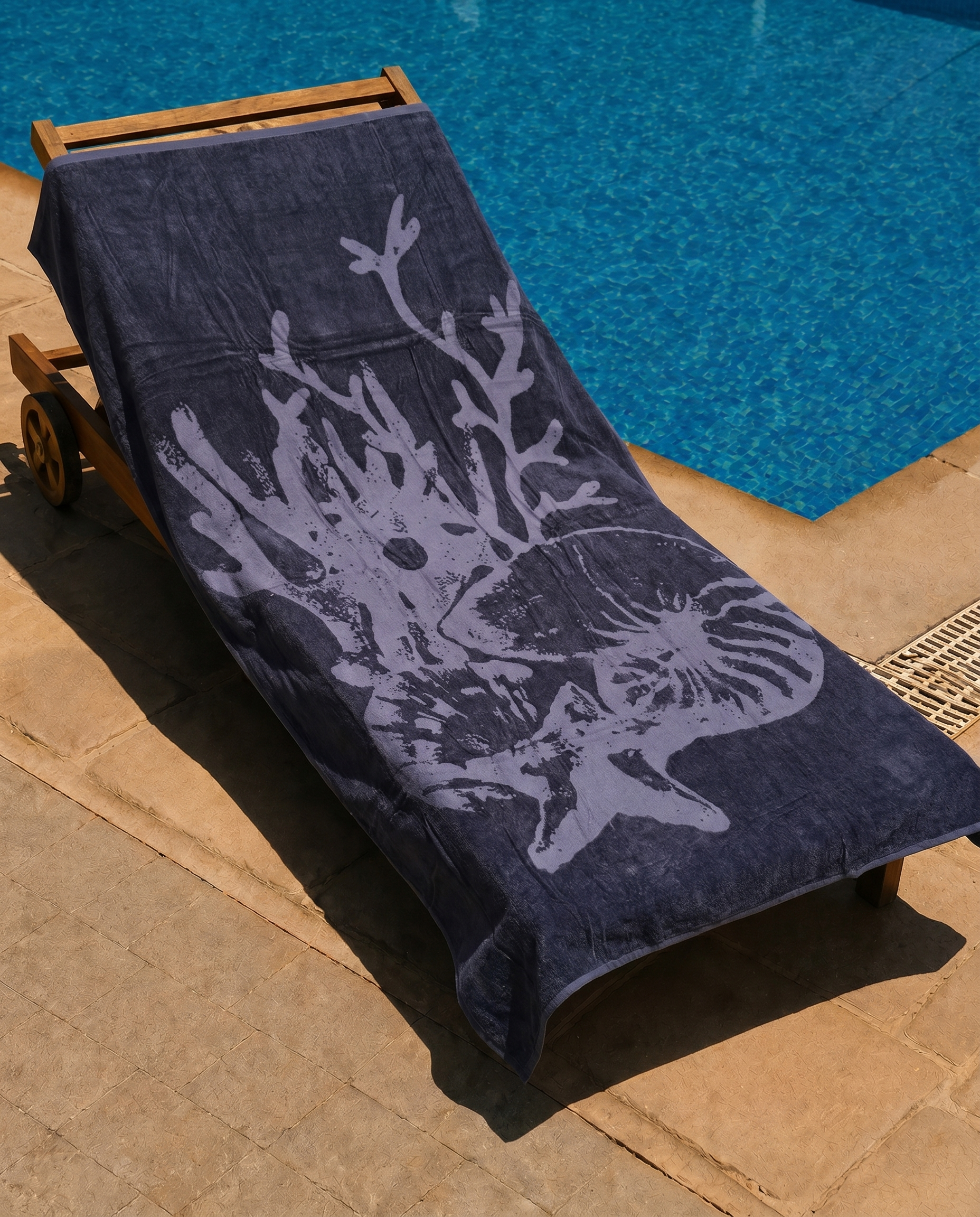 Slate Nautilus Beach Towel draped on a lounge chair