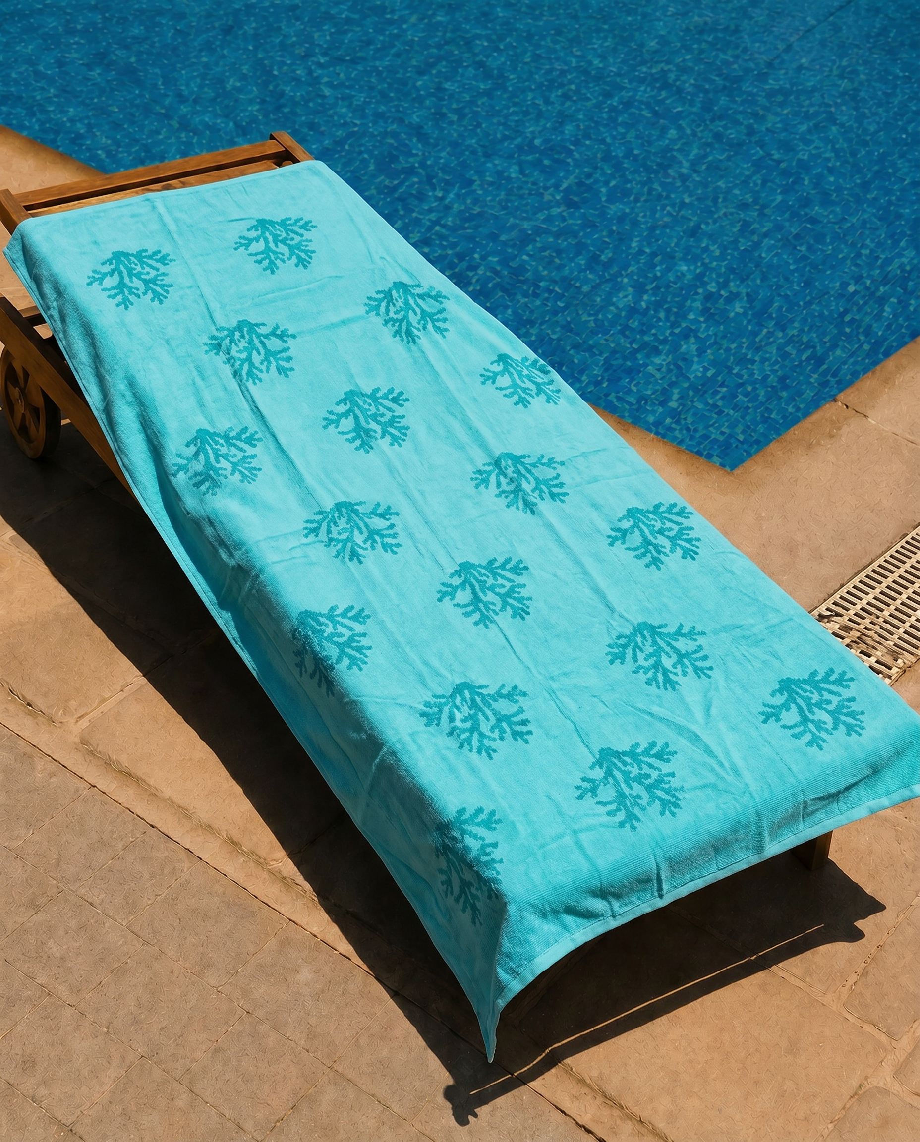 Aqua Coral Beach Towel draped on a lounge chair