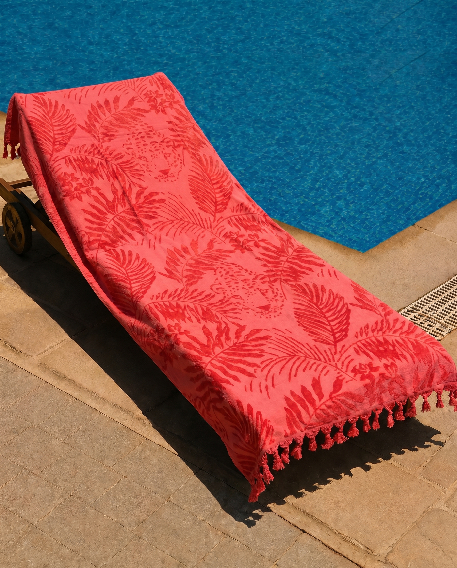 Coral Jungle Beach Towel draped on a lounge chair