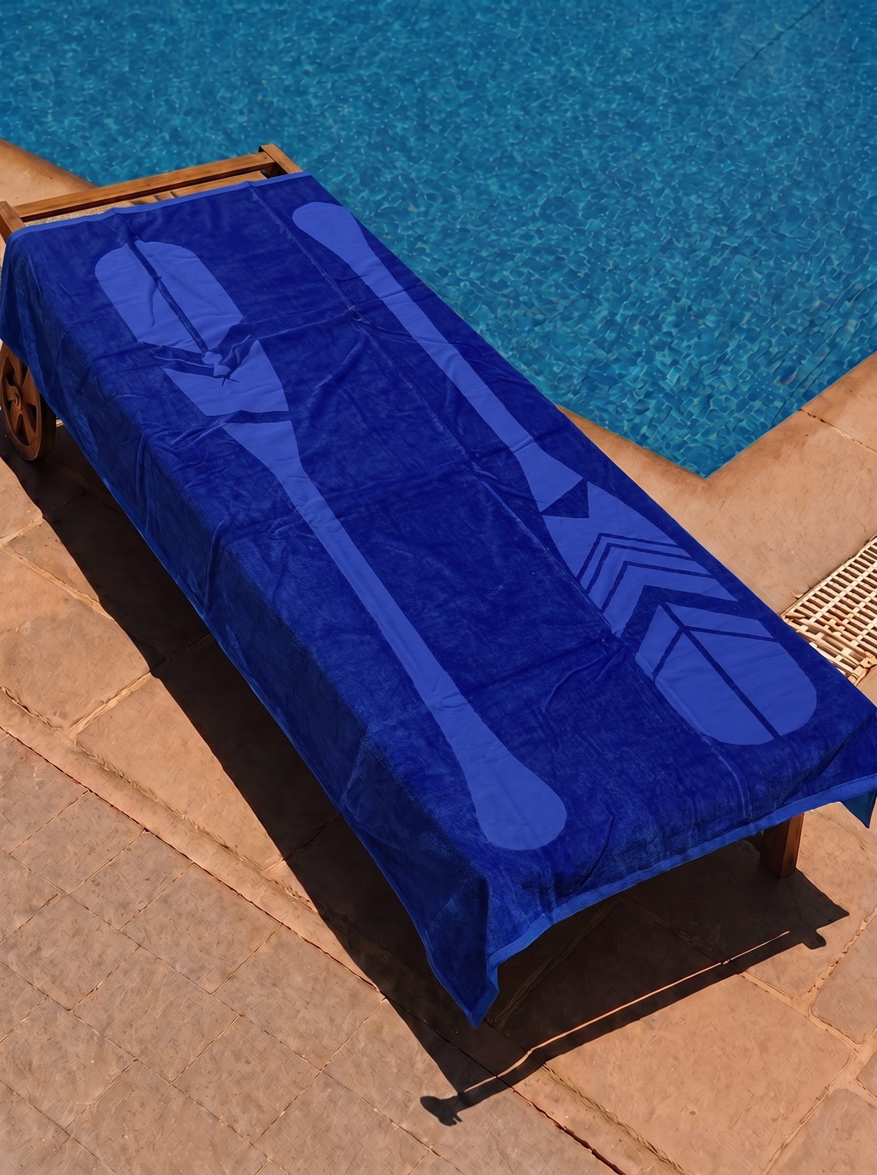 Blue tonal paddle towel on a poolside lounge chair