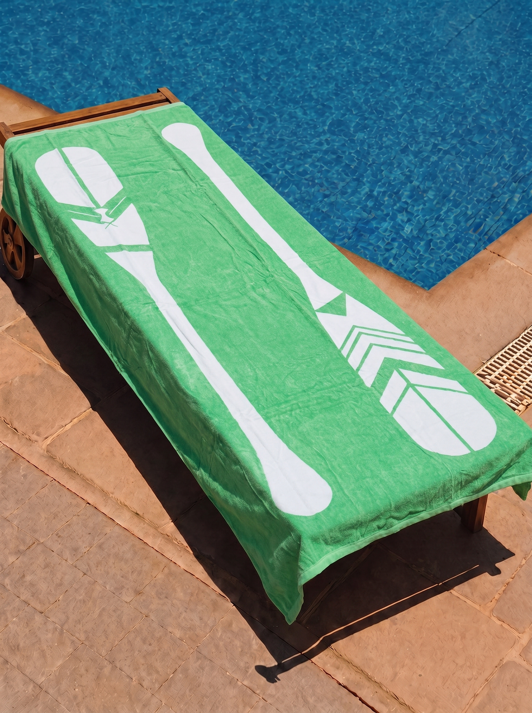 Green tonal paddle towel on a poolside lounge chair