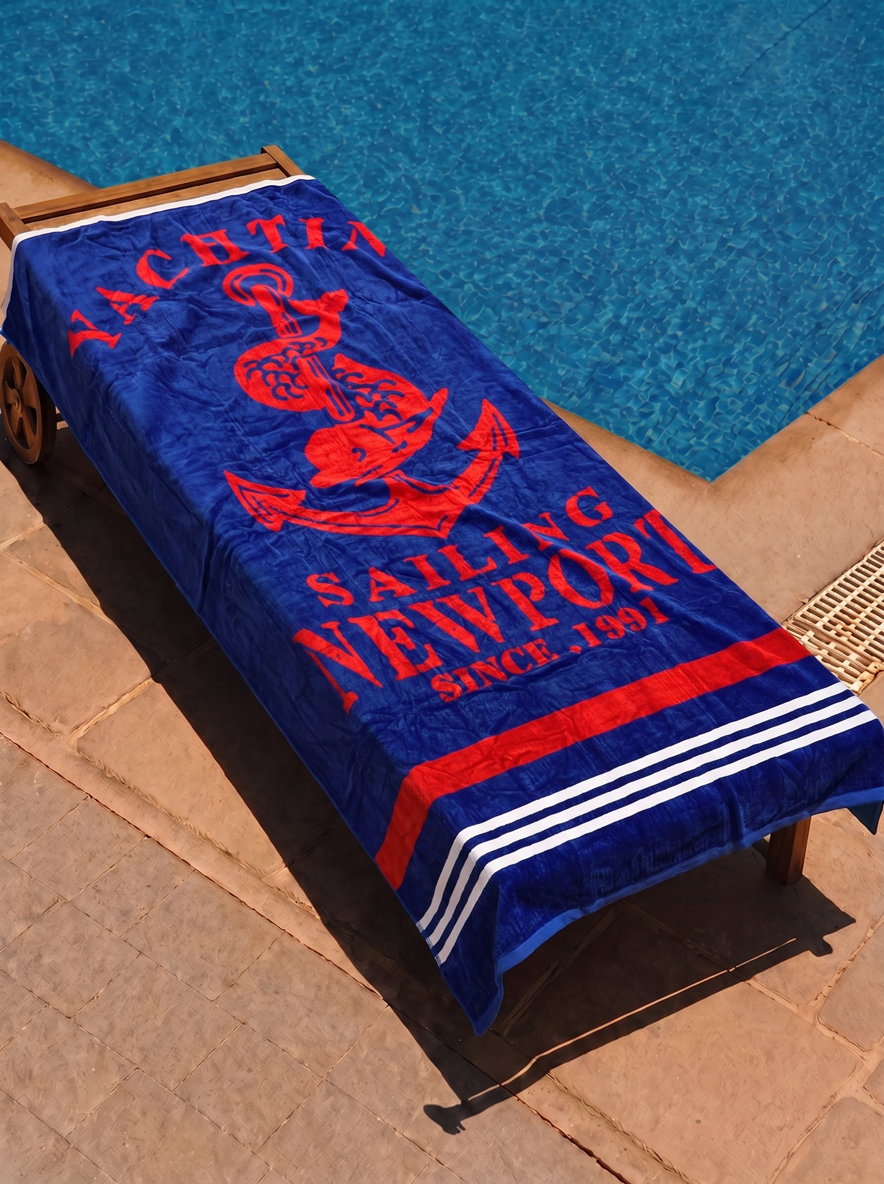 Yachting Newport anchor towel on a poolside lounge chair